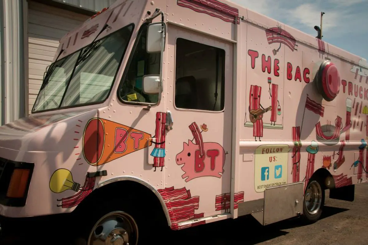 a red and white bus parked in front of a truck