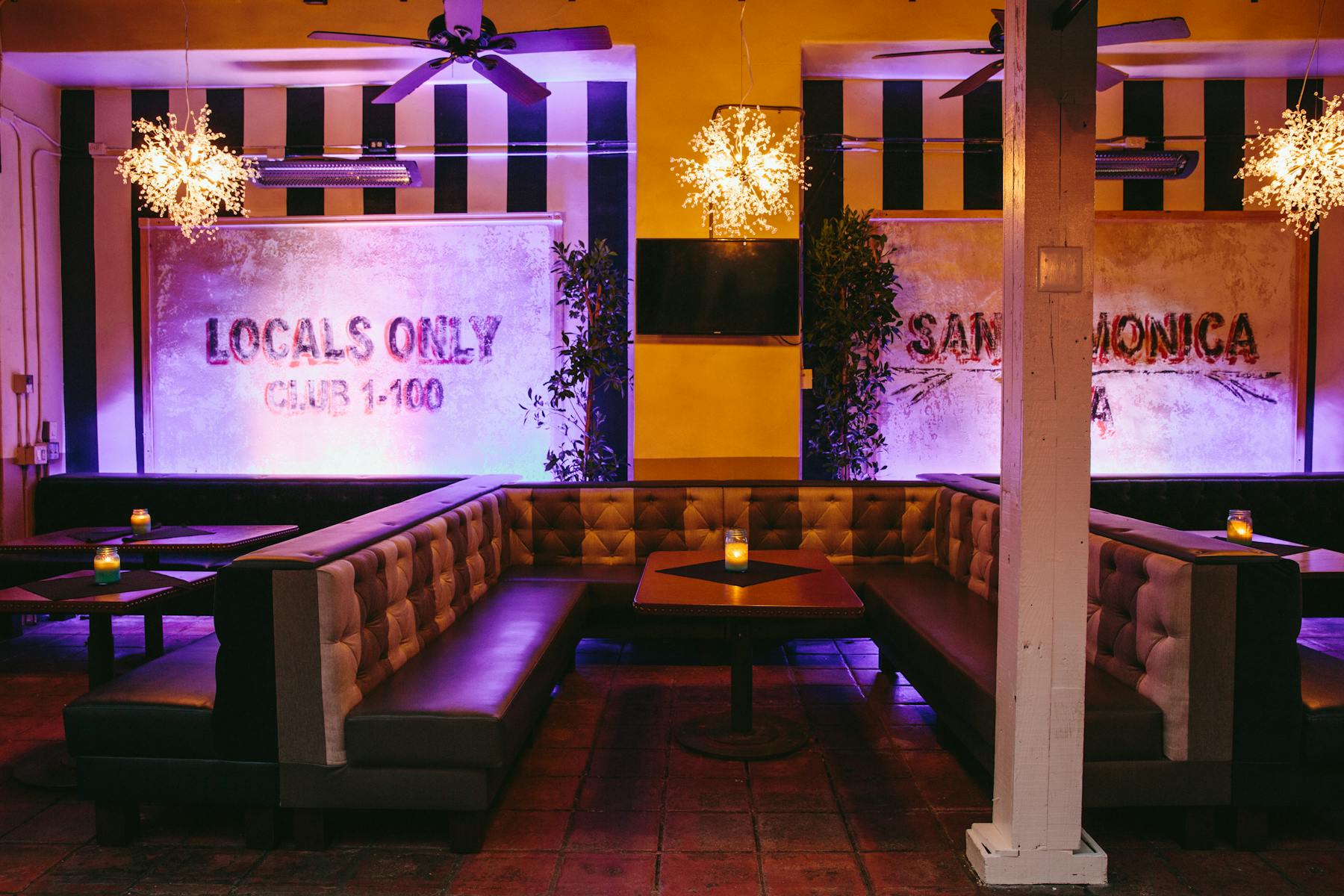 a room purple litten filled with seats and tables