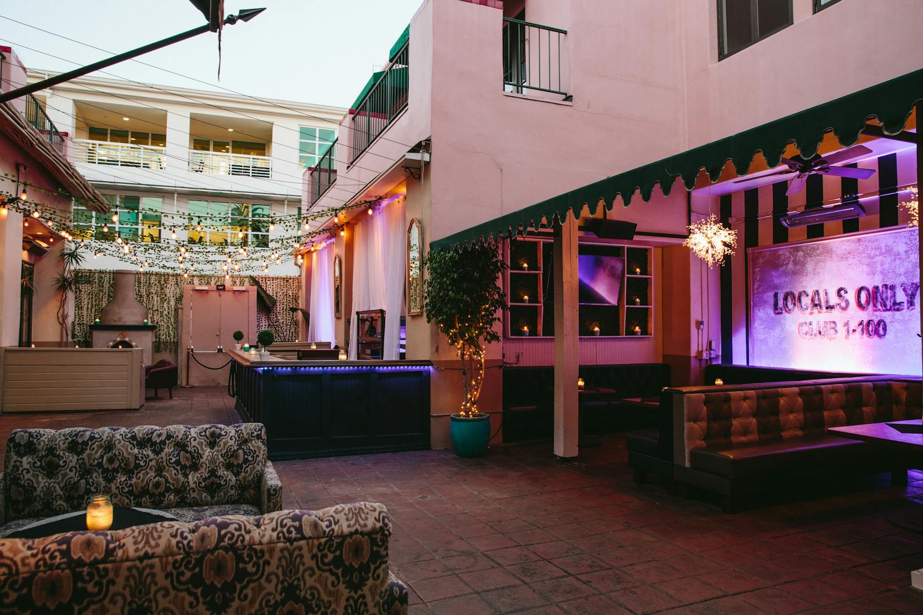 an exterior patio with sitting booths at the side of a large building