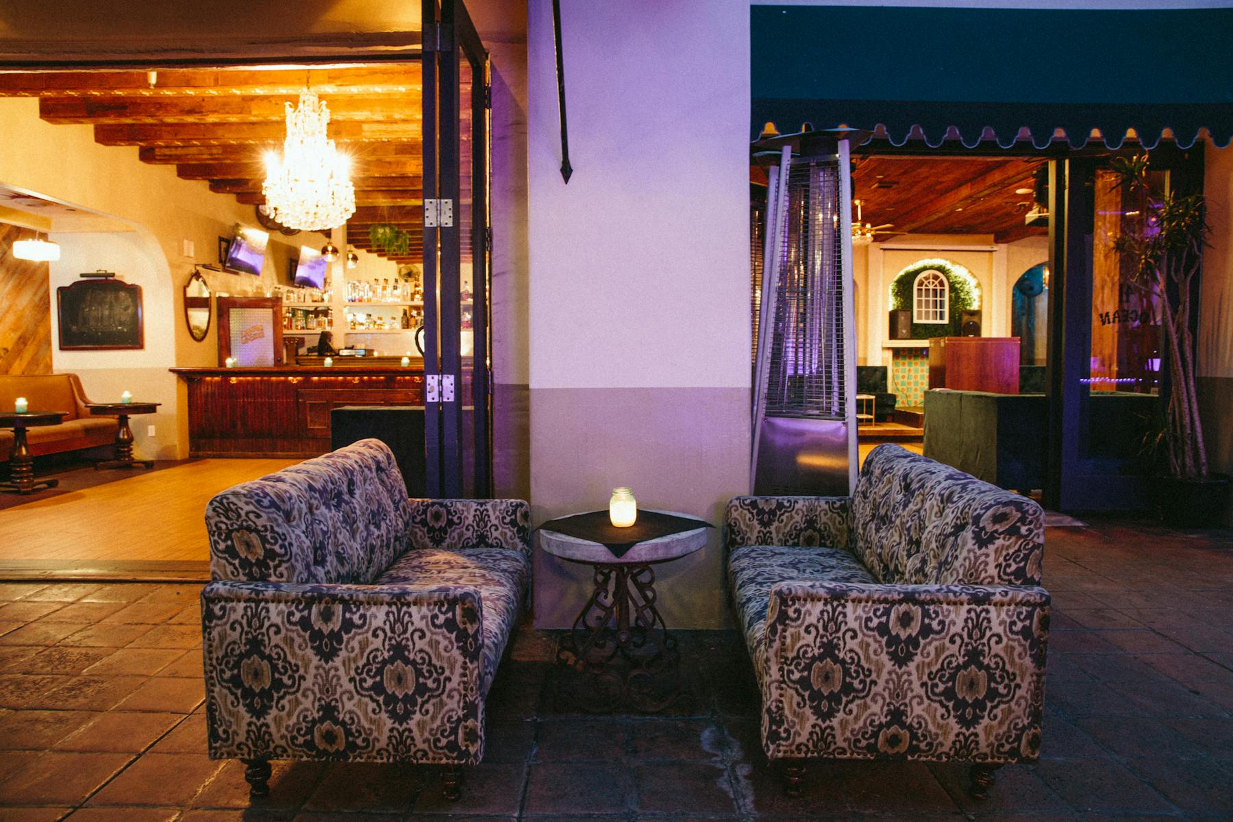 a sitting booth with a small table set in the middle litten up with purple light