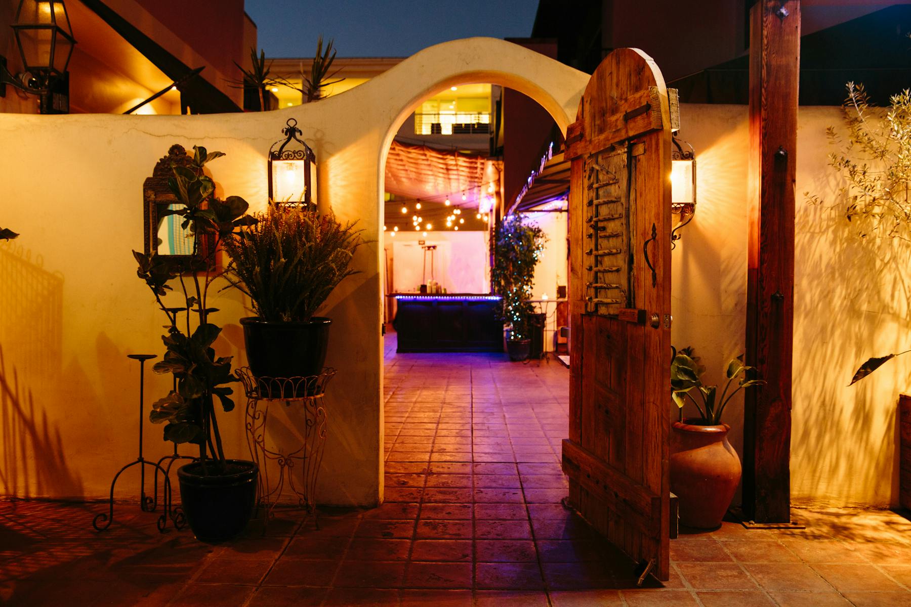 an entrance gate to an exterior patio litten up by a purple light