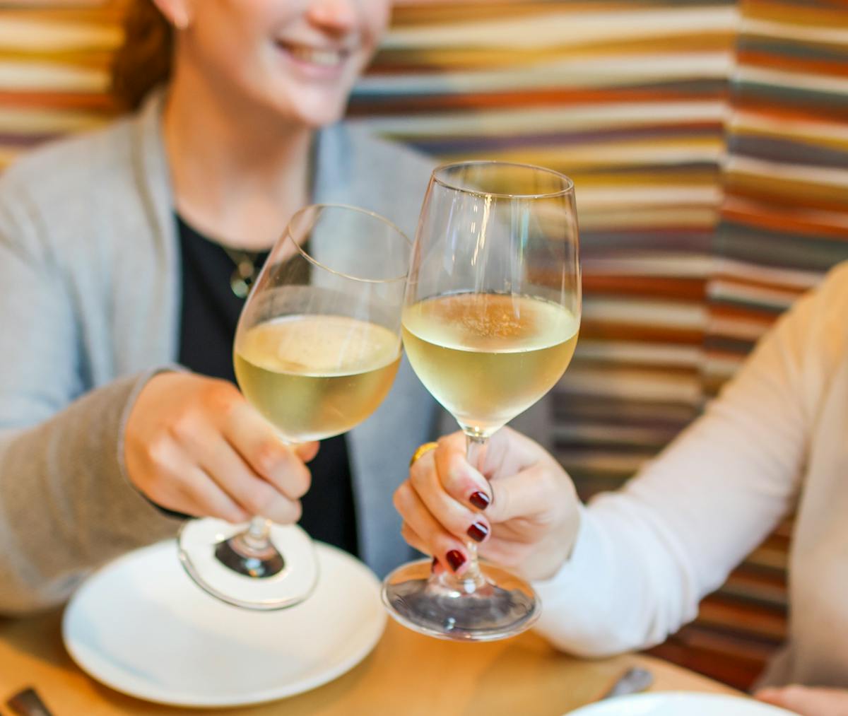 a woman sitting at a table with wine glasses