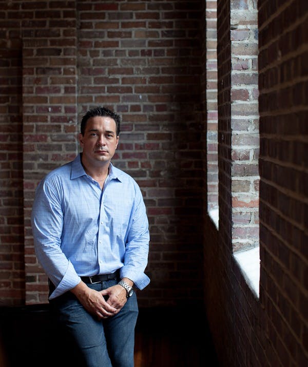 a man standing in front of a brick building