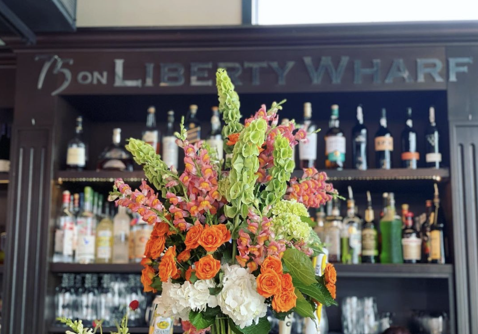 a vase of flowers sits in front of a store window