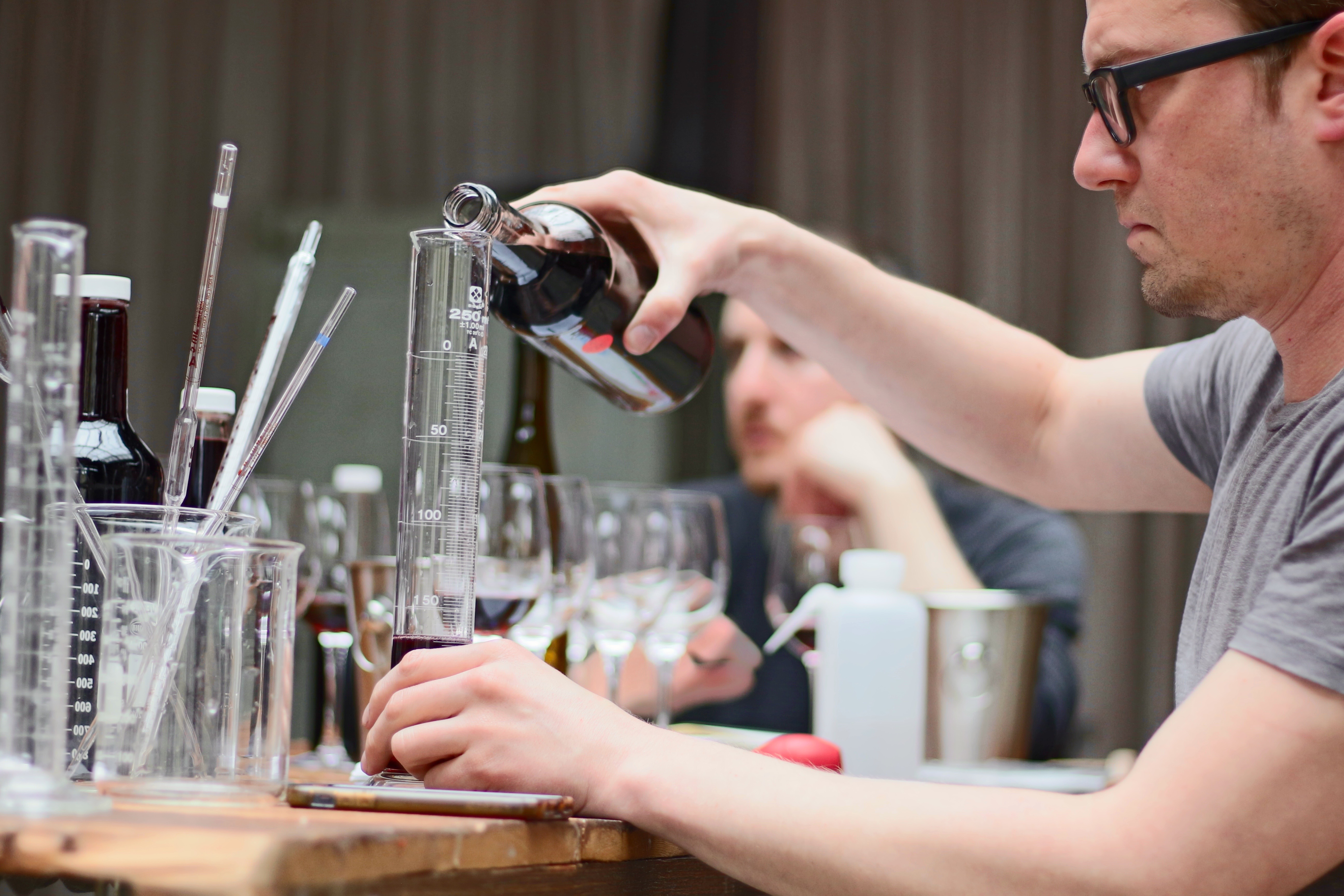 Winemaker Blending red wine in graduated cylinder