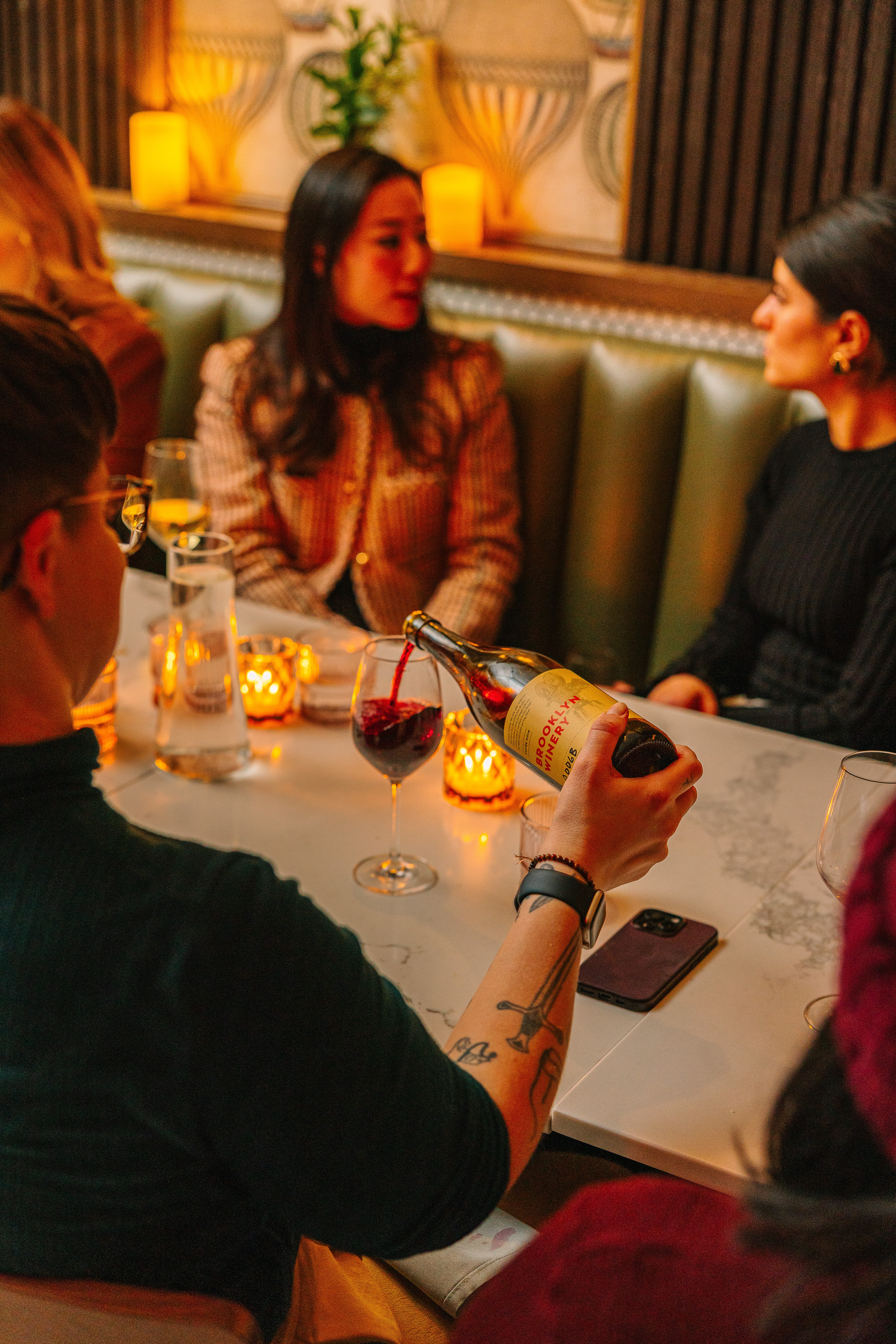 pouring red wine at a table in the wine bar