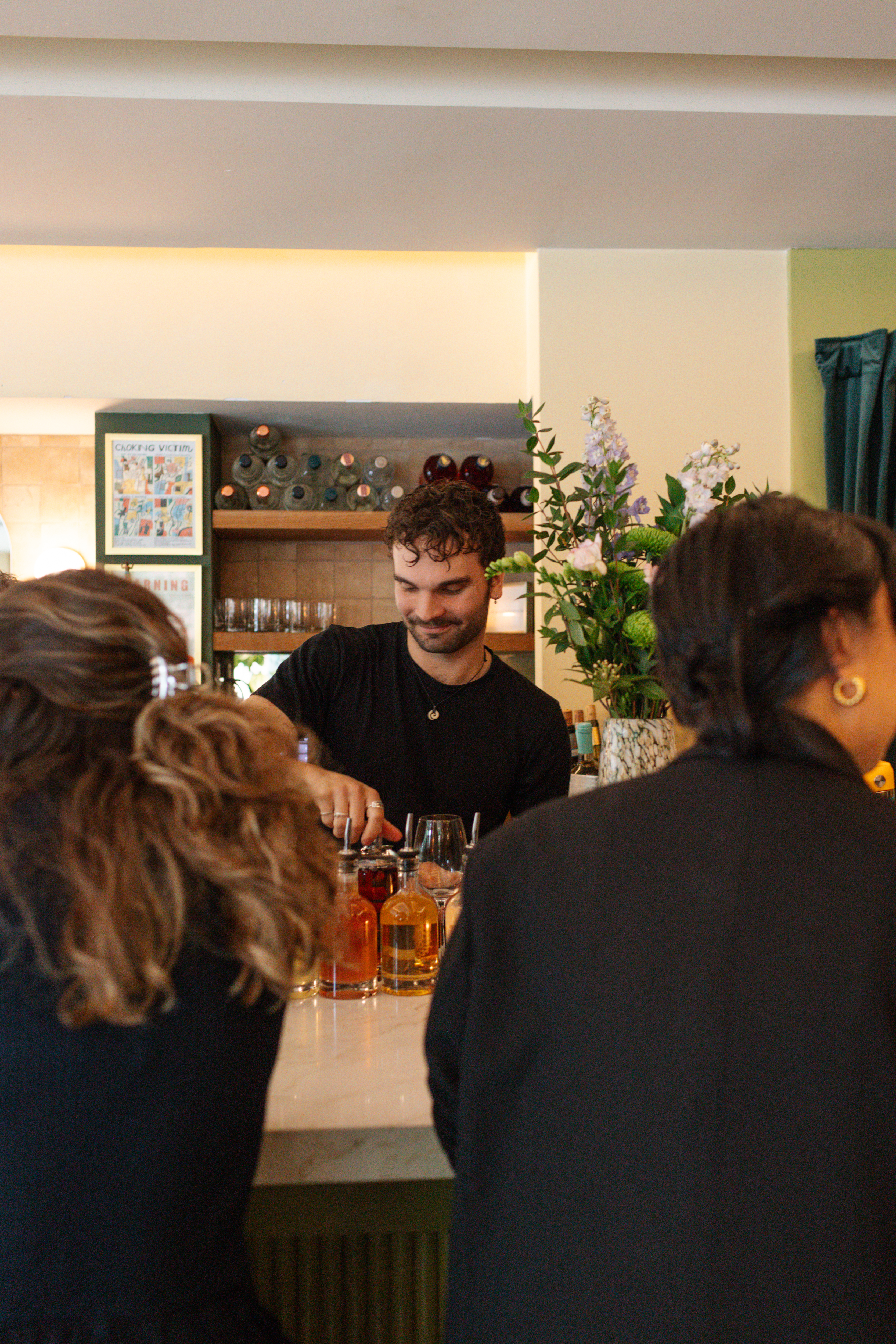 a man standing at a bar with a group of people around