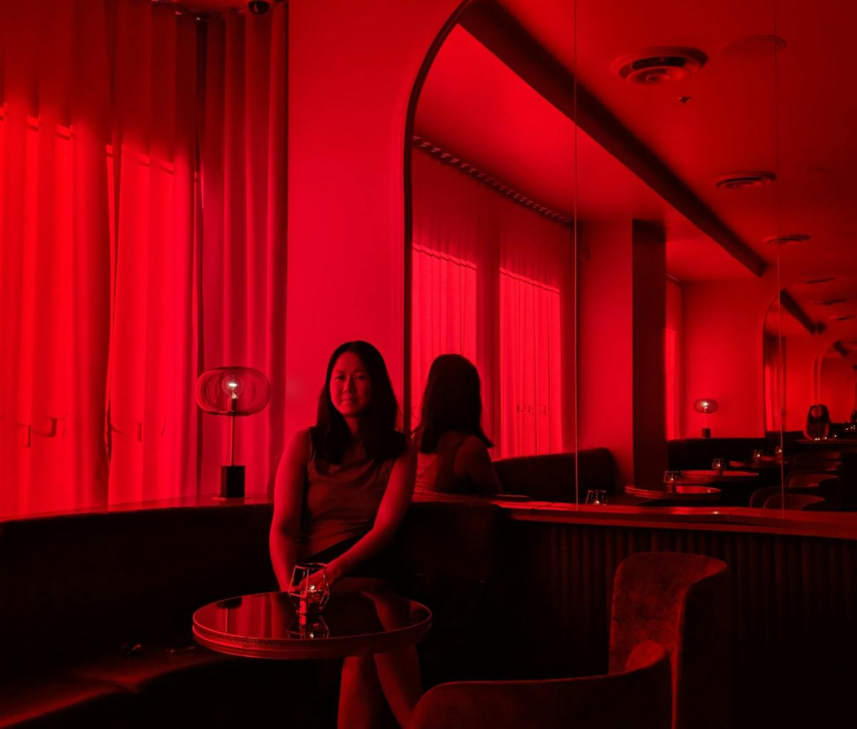 a person sitting at a table in front of a piano
