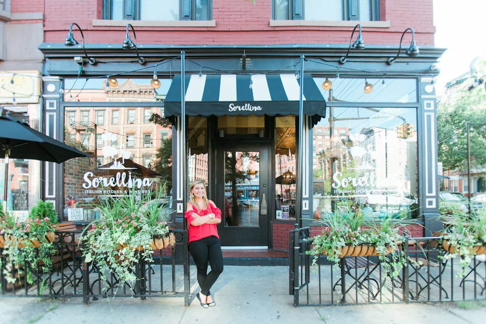 a woman sitting on a bench in front of a building