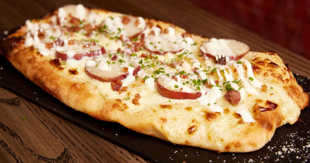 a pizza sitting on top of a wooden cutting board