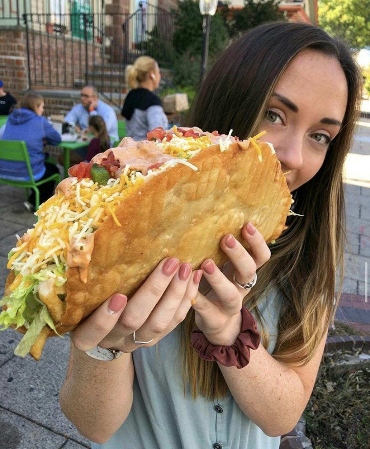 a woman holding a sandwich in her hand