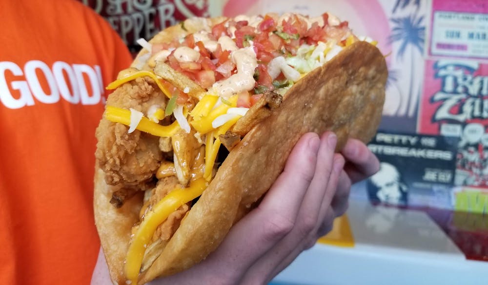 a close up of a person holding a hot dog on a bun
