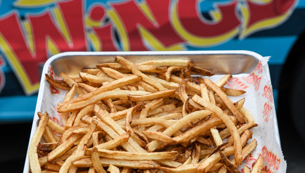 a close up of a sandwich sitting on top of a pile of fries
