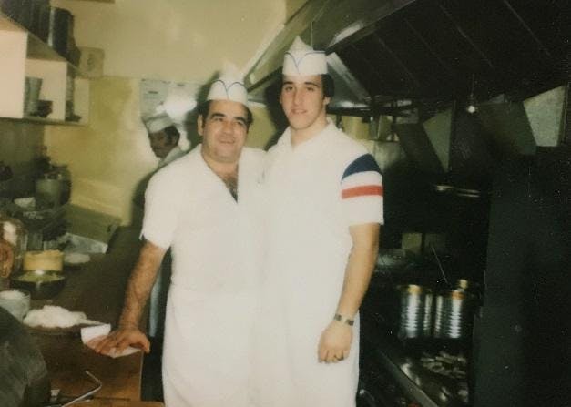 a person standing in a kitchen posing for a picture