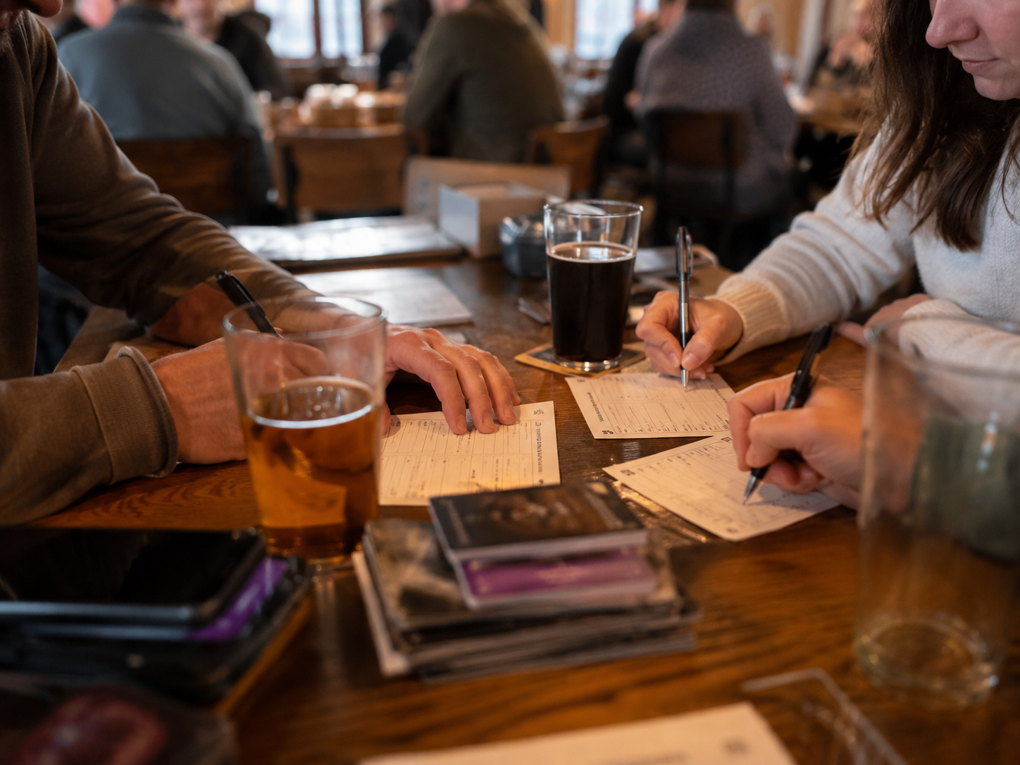 a group of people sitting at a table writing on paper