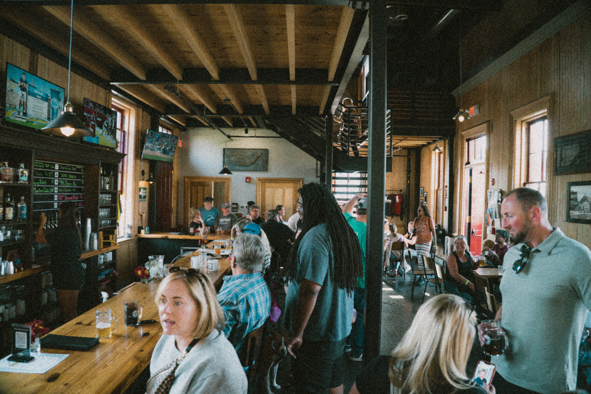 a group of people sitting at tables in a room with a bar