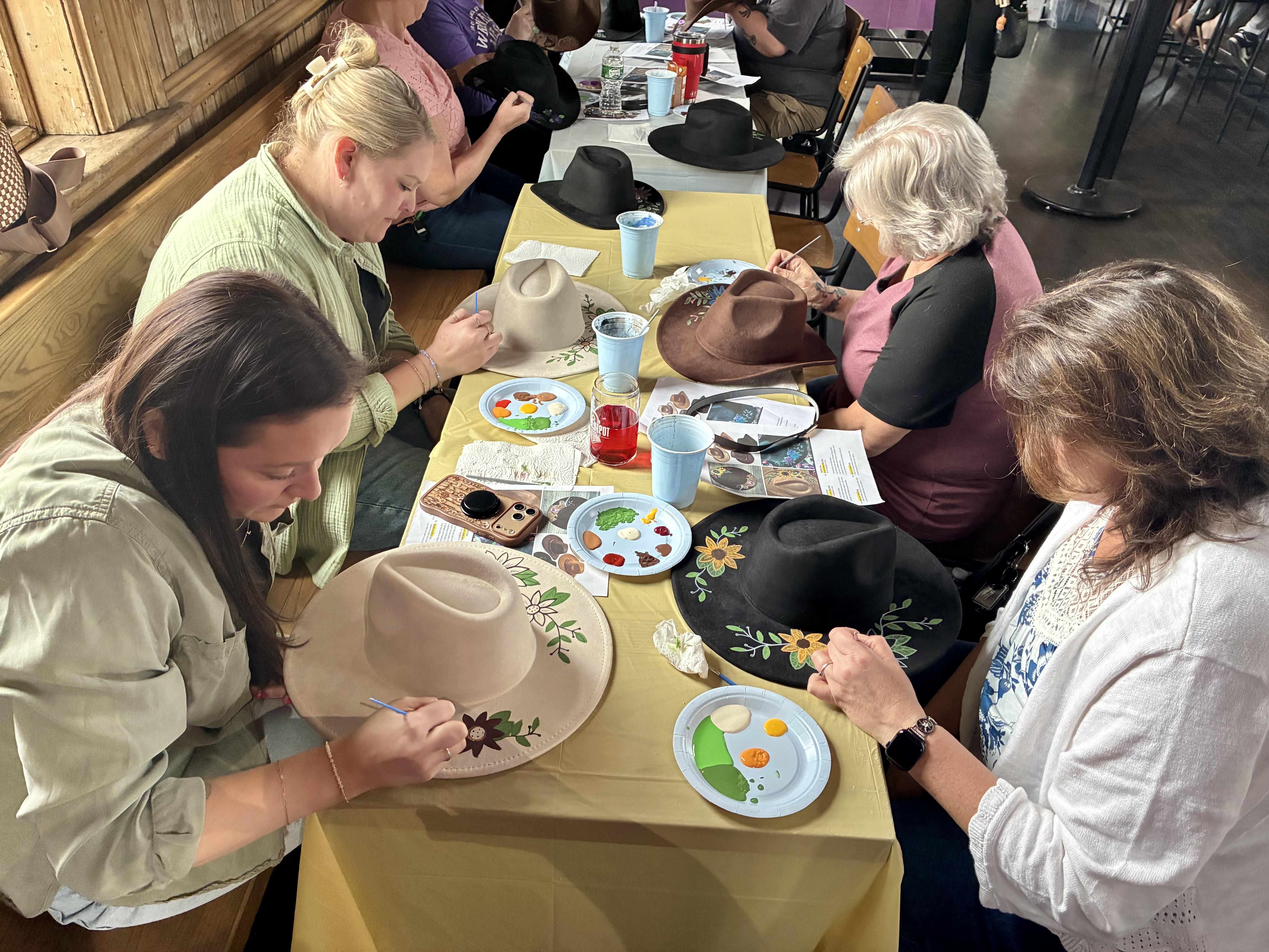 a group of women painting hats