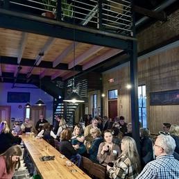 Guests gathered inside Upper Depot Brewing Co around the long bar and mezzanine seating