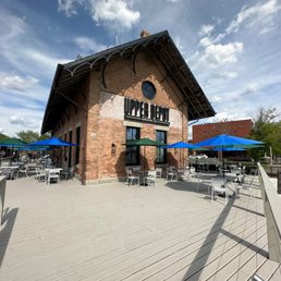 Upper Depot Brewing Co exterior in Hudson, New York, with patio seating and blue umbrellas