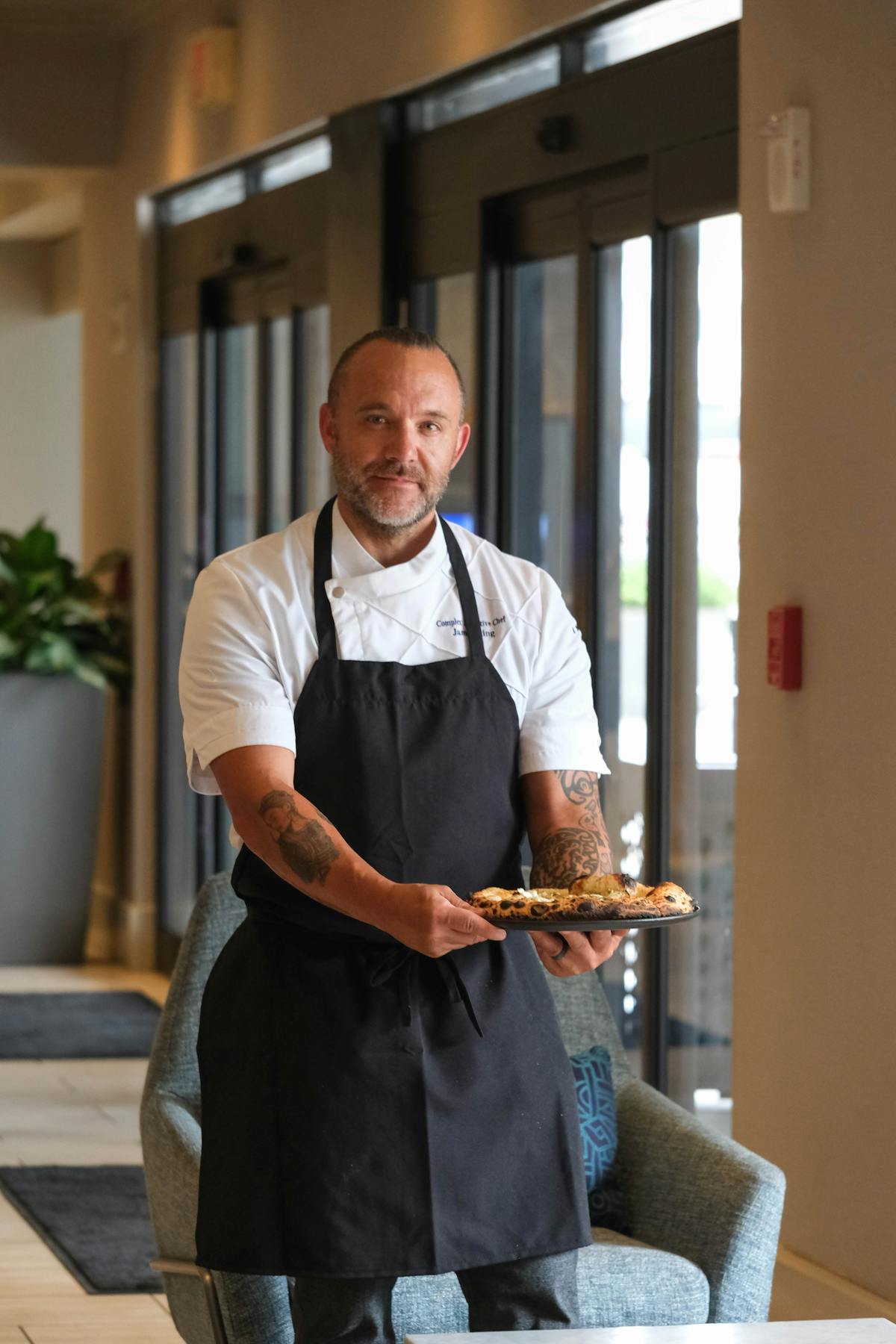 Chef James King Holding a Pizza