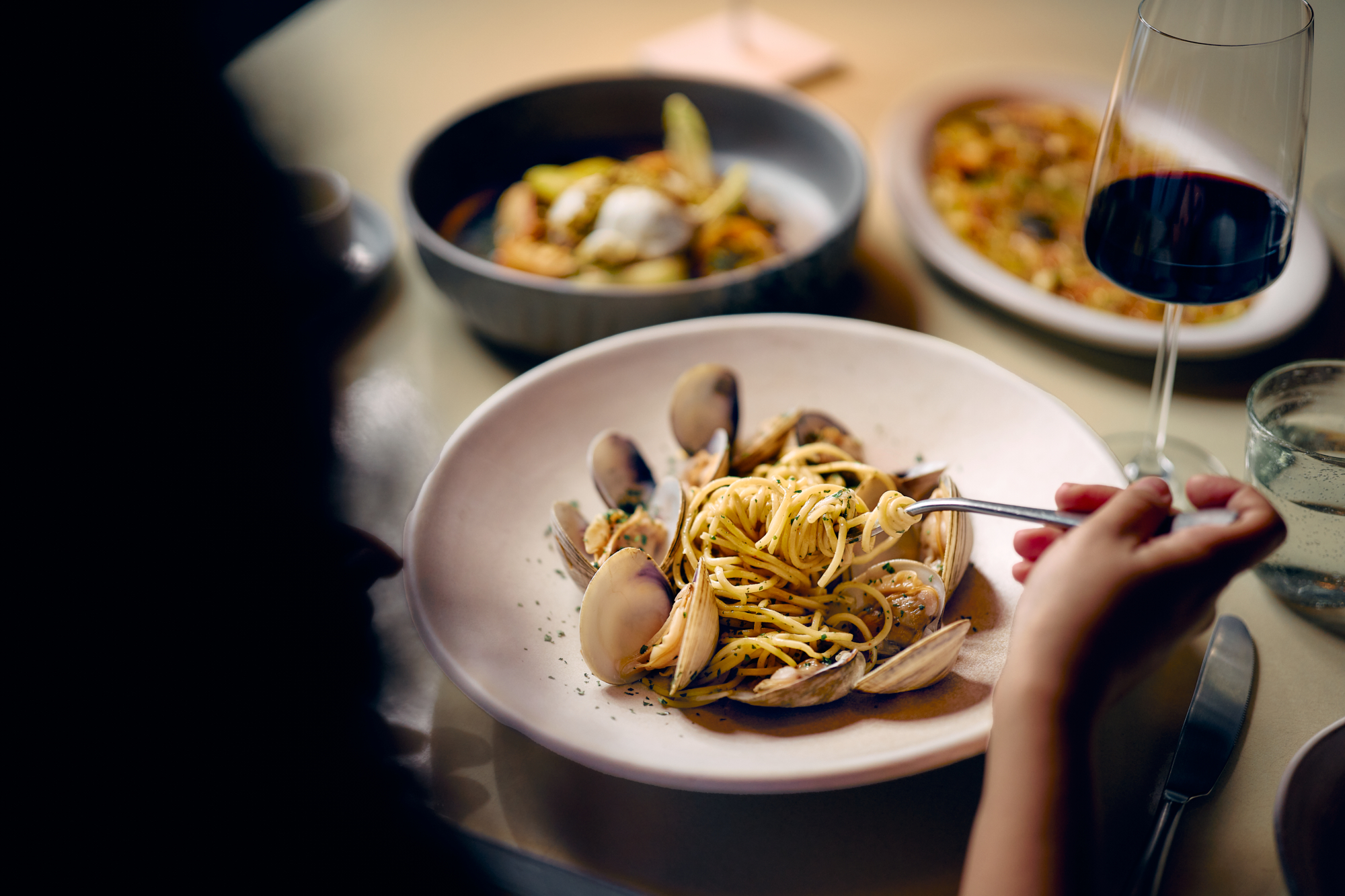 Clam pasta served in a shallow bowl, with linguine and shellfish, enjoyed at Palmerio Restaurant during dinner