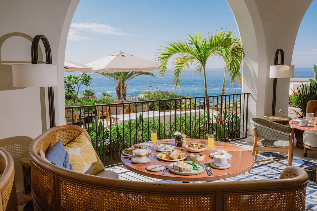 A scenic view of the ocean from a hotel patio, showcasing blue waters and a clear sky