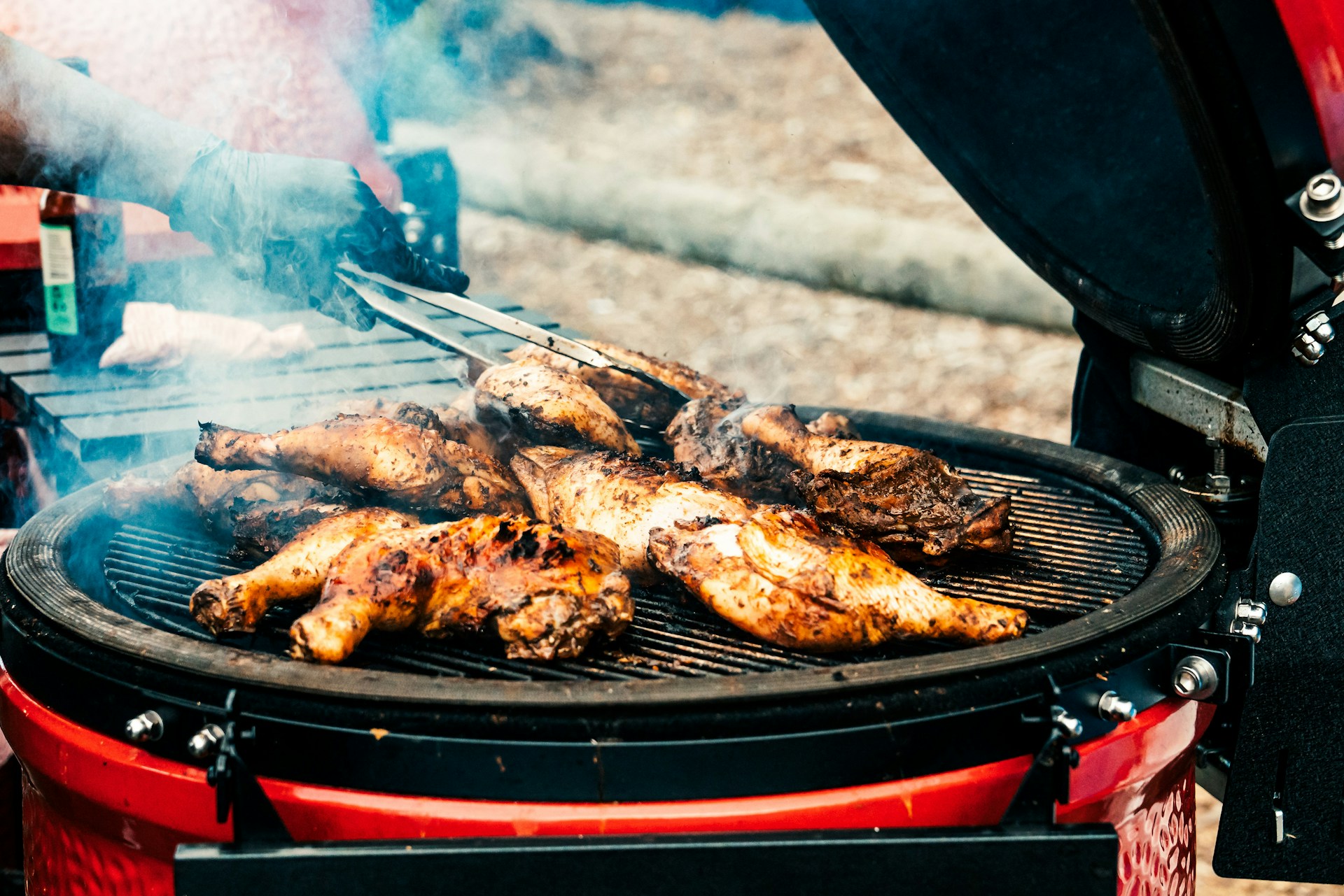 a person cooking hot dogs on a grill