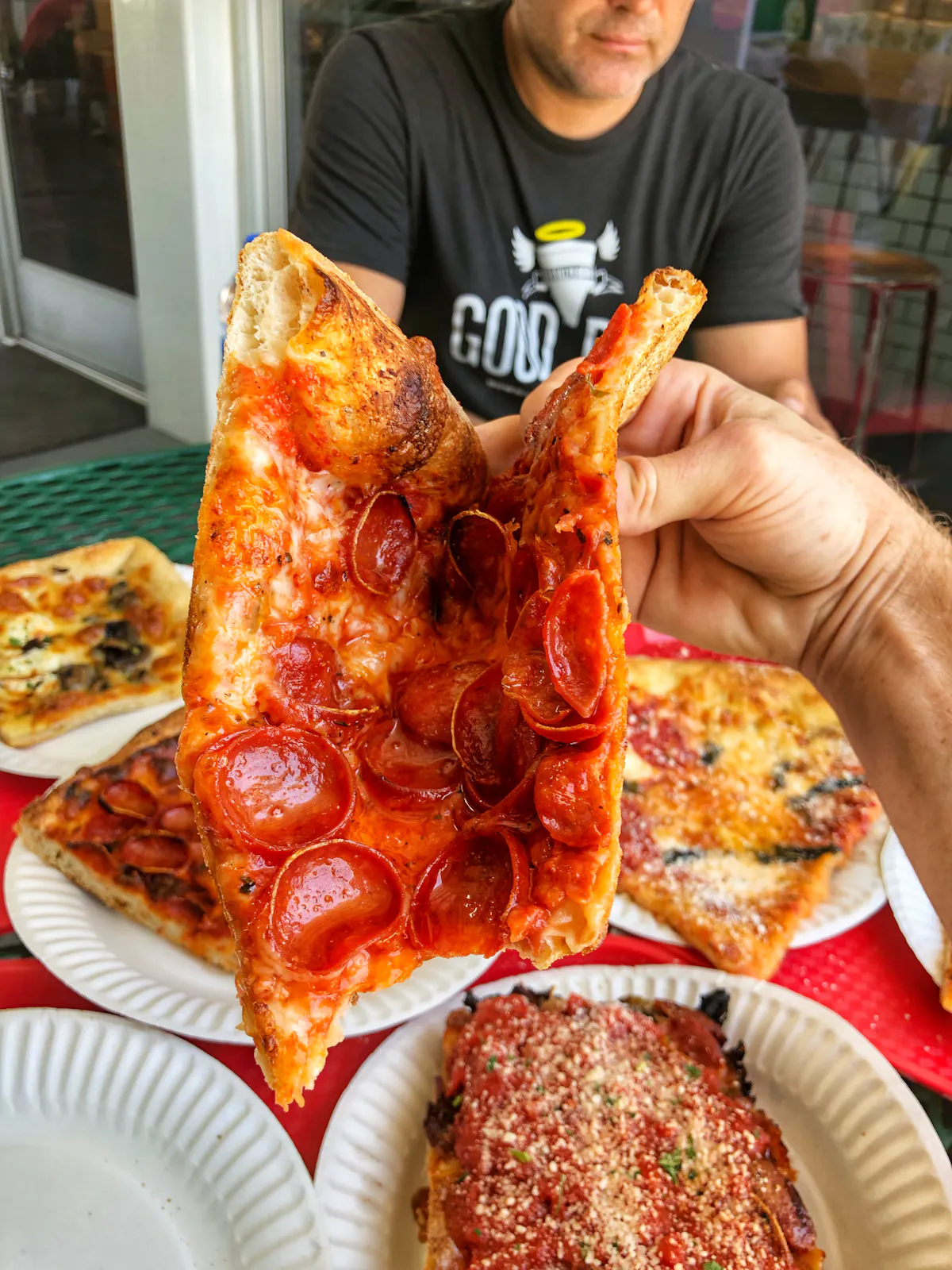 a person holding a slice of pizza