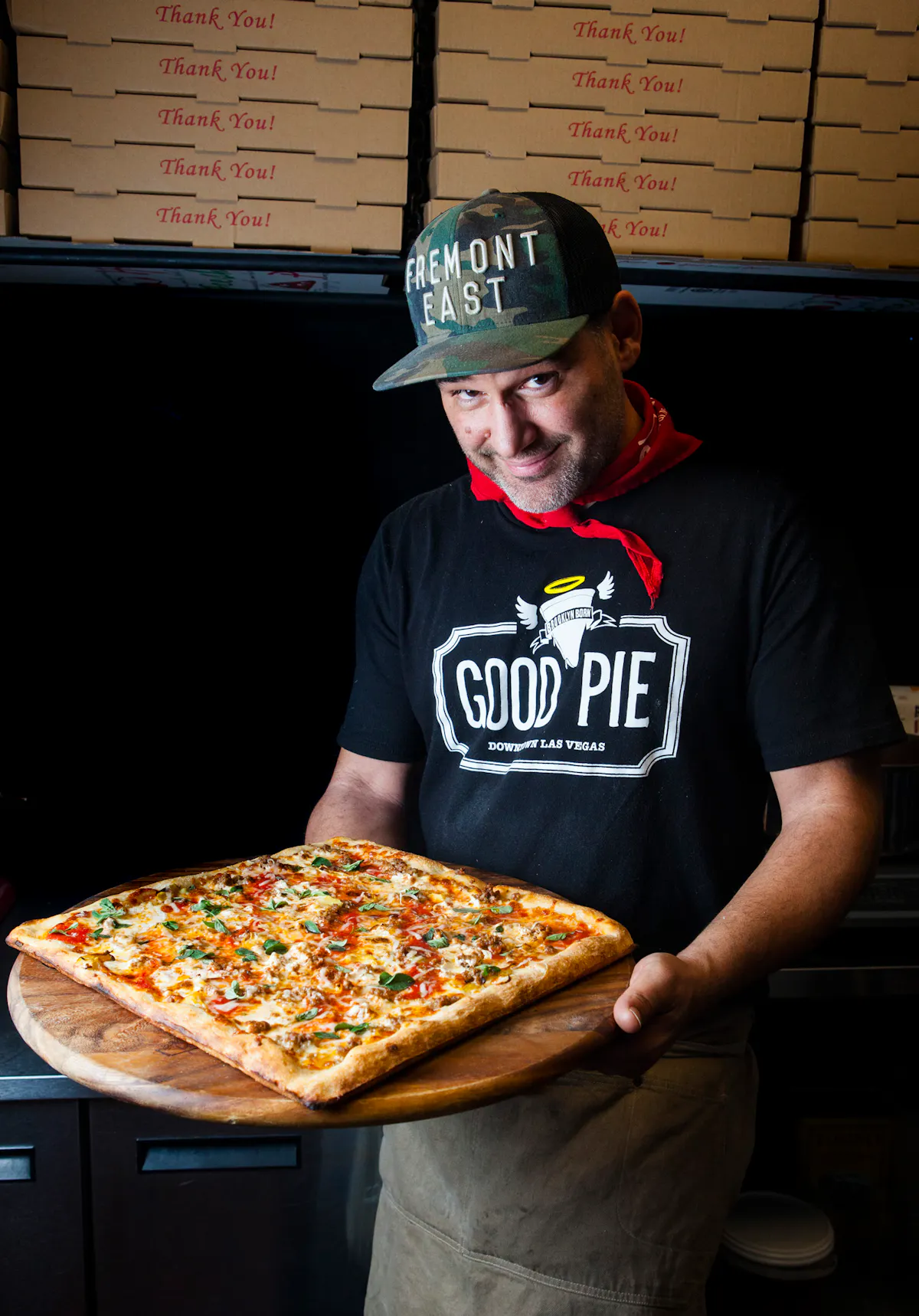 a man holding a box of pizza