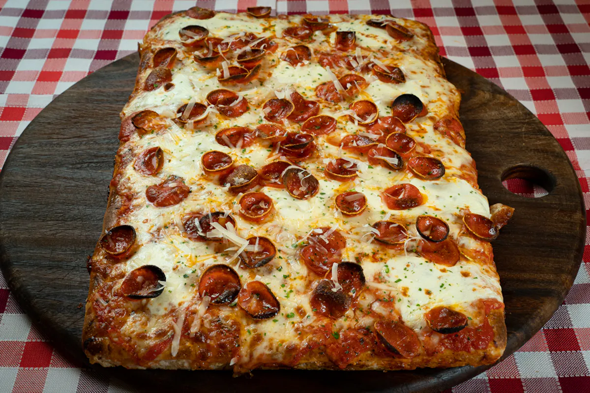 a large pepperoni pizza sitting on top of a table