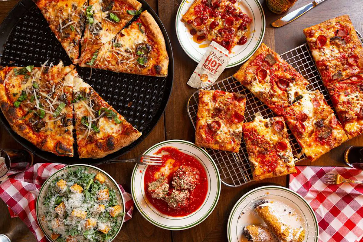 a pizza sitting on top of a table filled with food