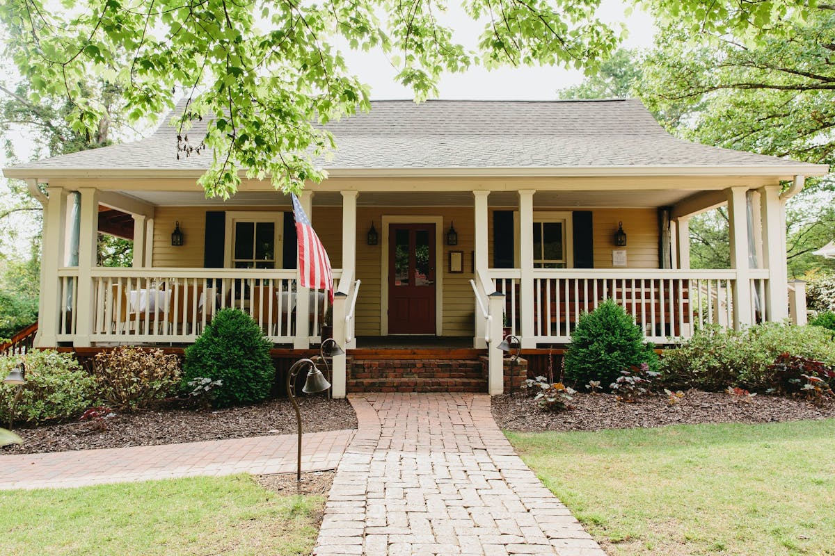 a house with bushes in front of a brick building