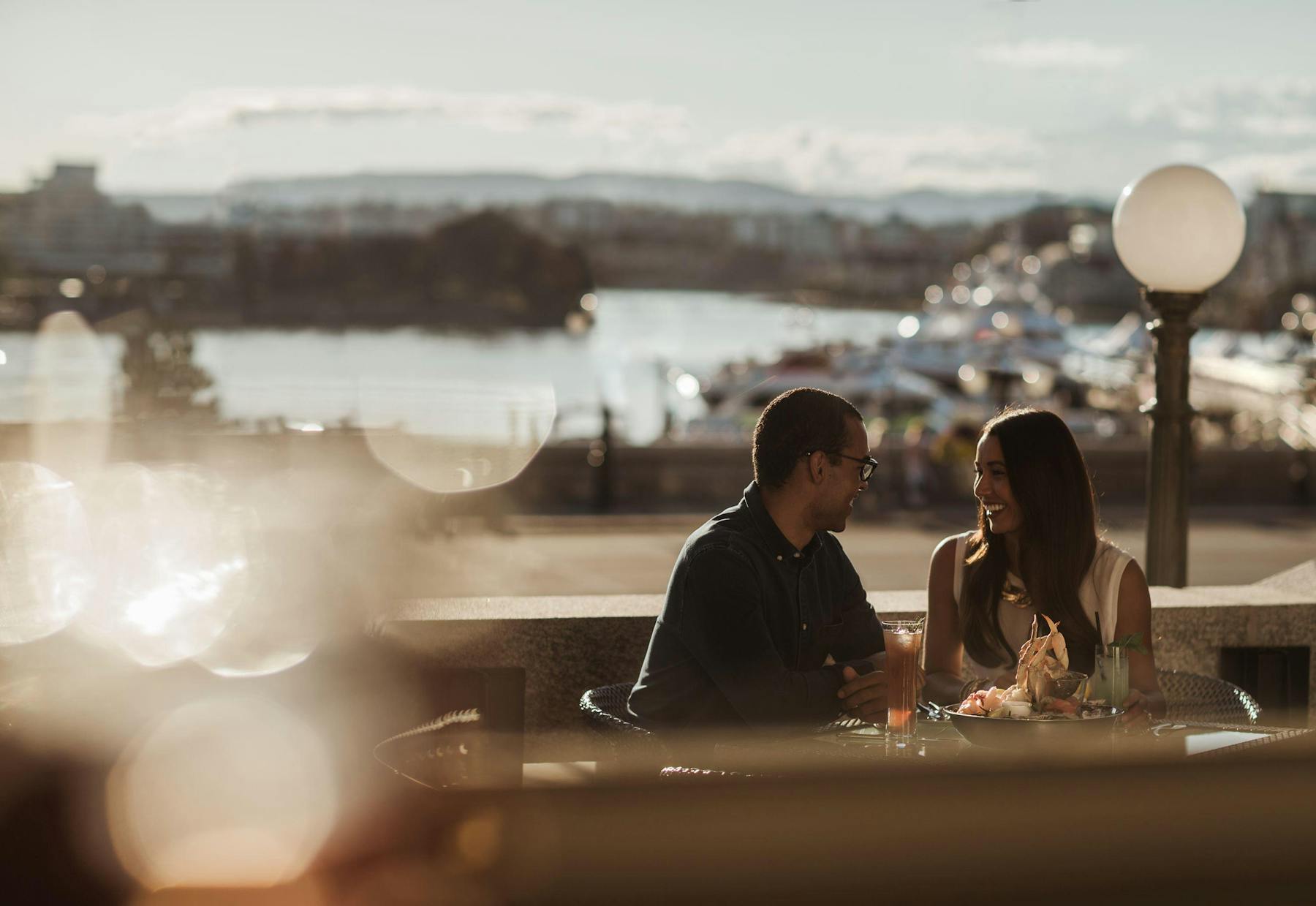 a person sitting at a table in front of water