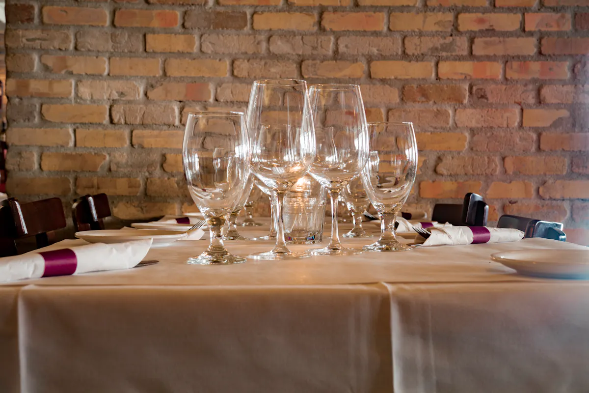 a person sitting at a table with wine glasses
