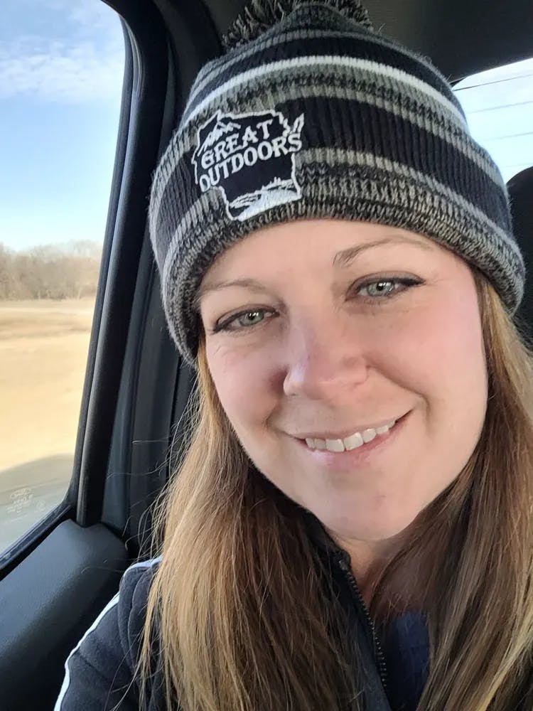 a woman wearing a hat and smiling at the camera