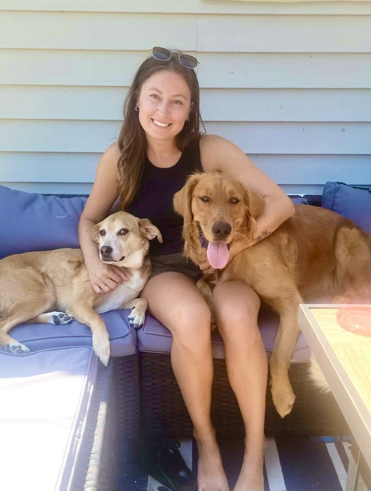 a woman holding a dog posing for the camera