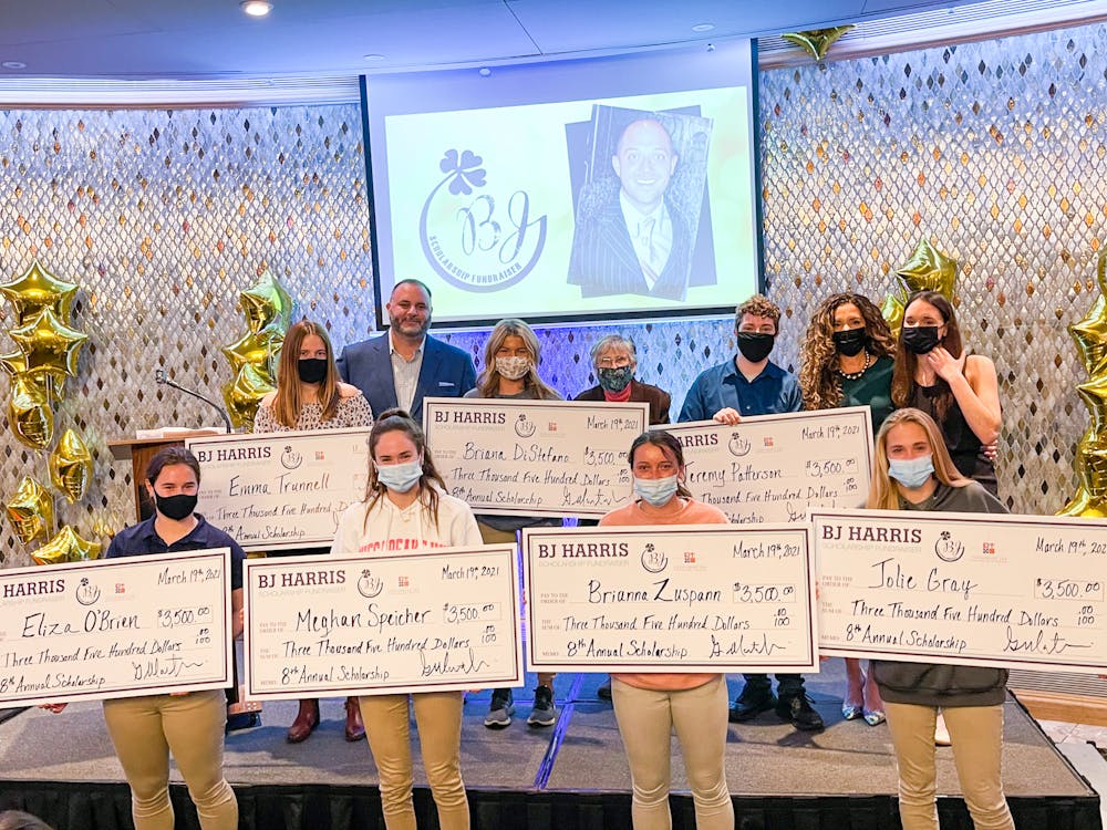 a group of people holding a sign posing for the camera