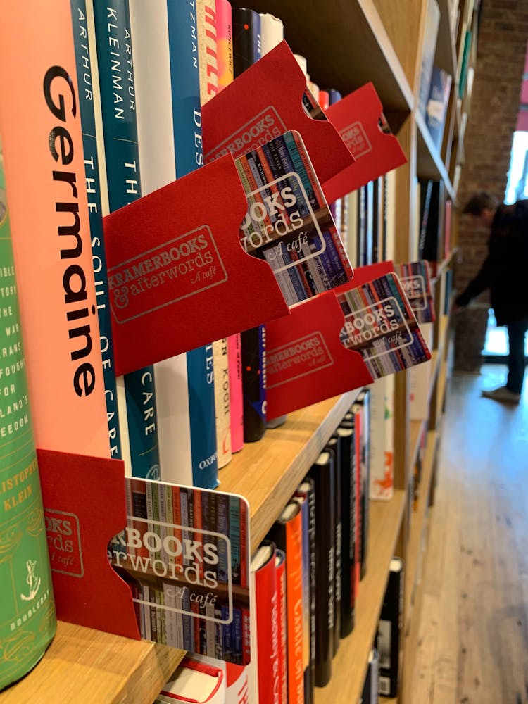 a stack of flyers on a table next to a book shelf