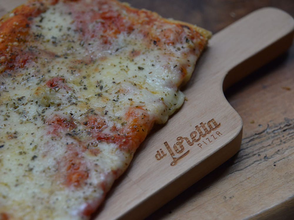 a slice of pizza sitting on top of a wooden cutting board