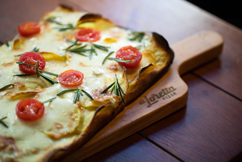 a slice of pizza sitting on top of a wooden cutting board