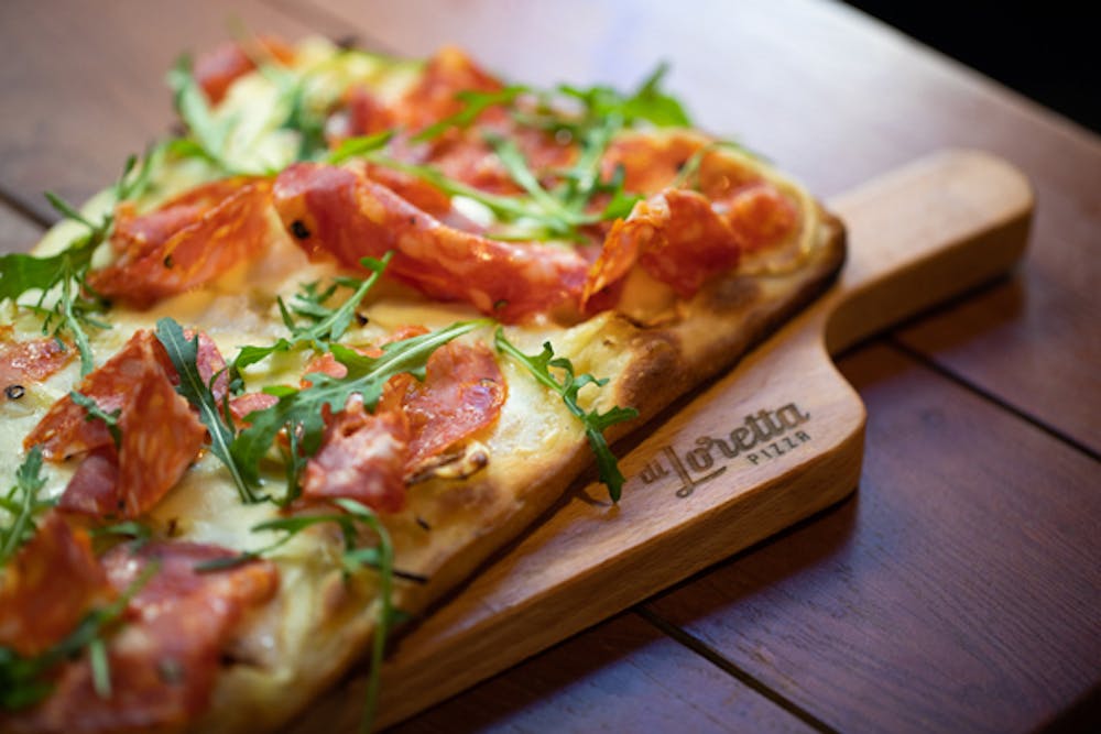 a slice of pizza sitting on top of a wooden cutting board
