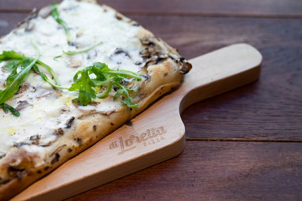 a slice of pizza sitting on top of a wooden cutting board