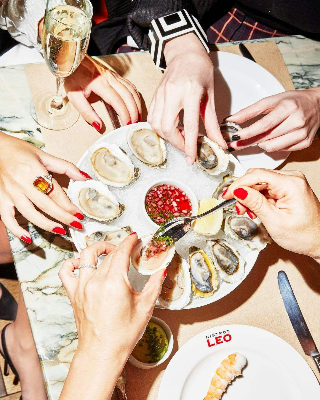 people reaching for raw oysters