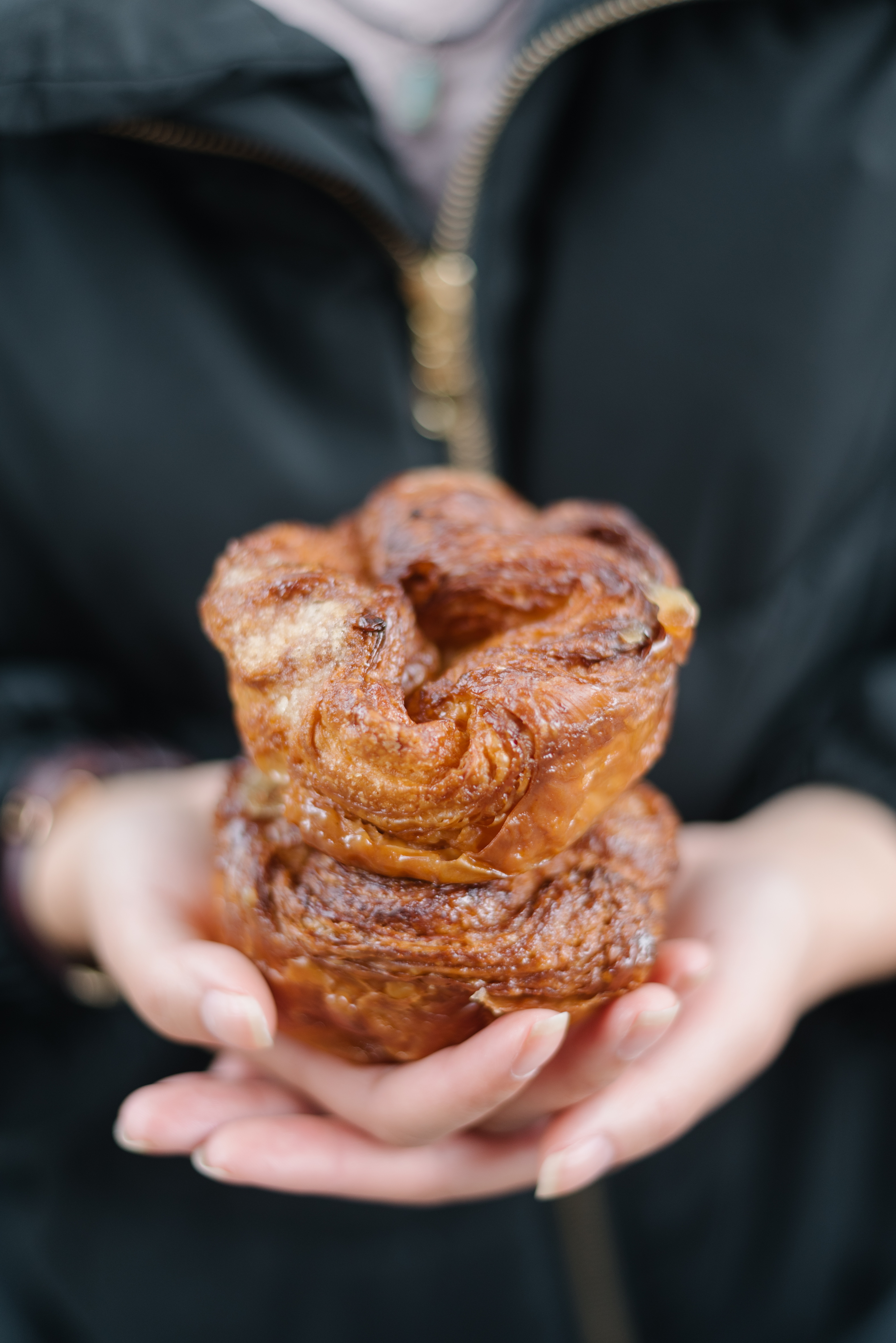 a close up of a person holding a donut in his hand