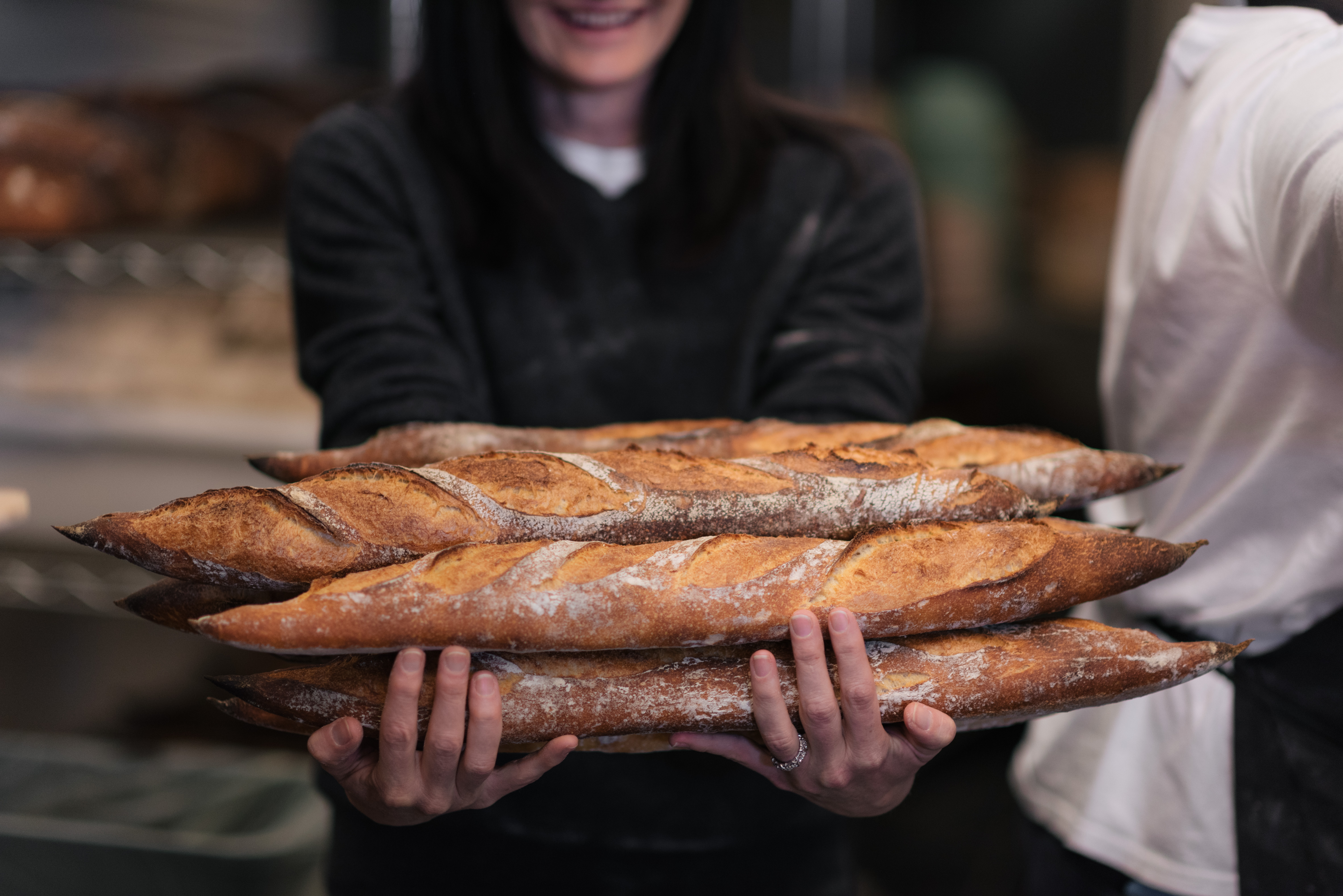 a person holding a hot dog on a grill