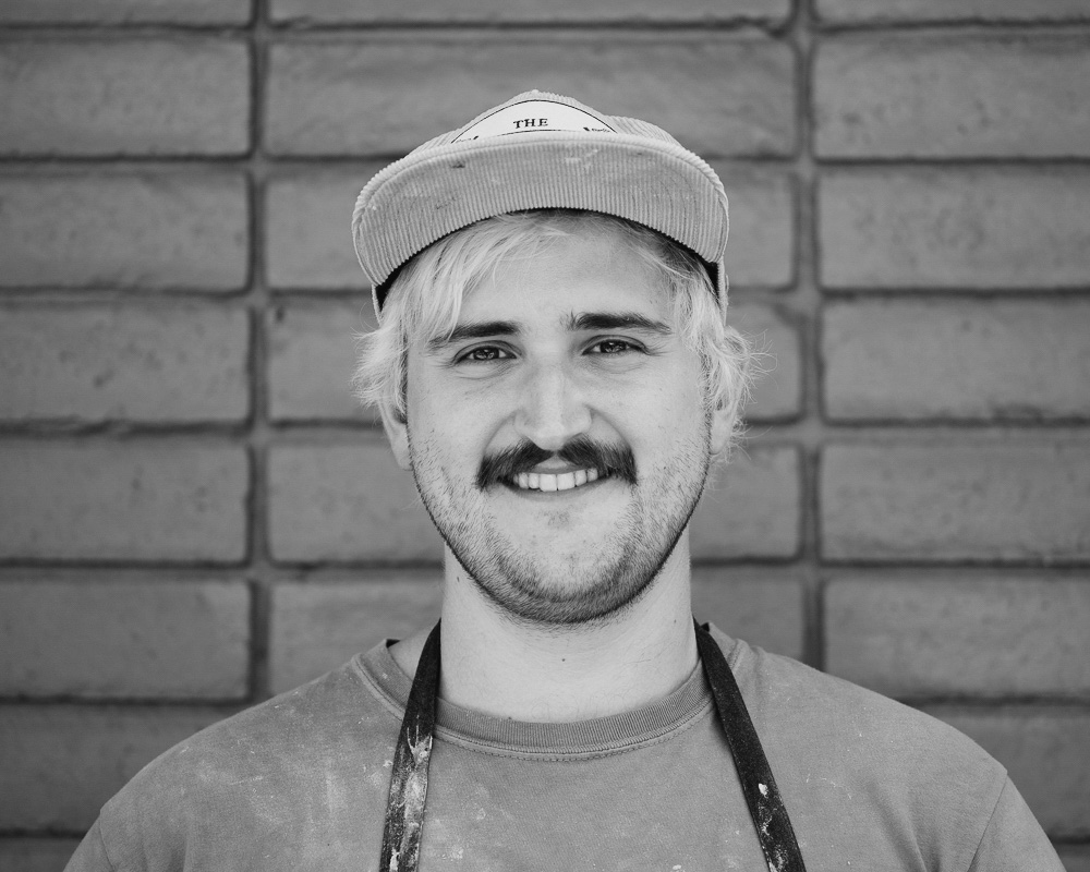 a man with a mustache wearing a baseball cap