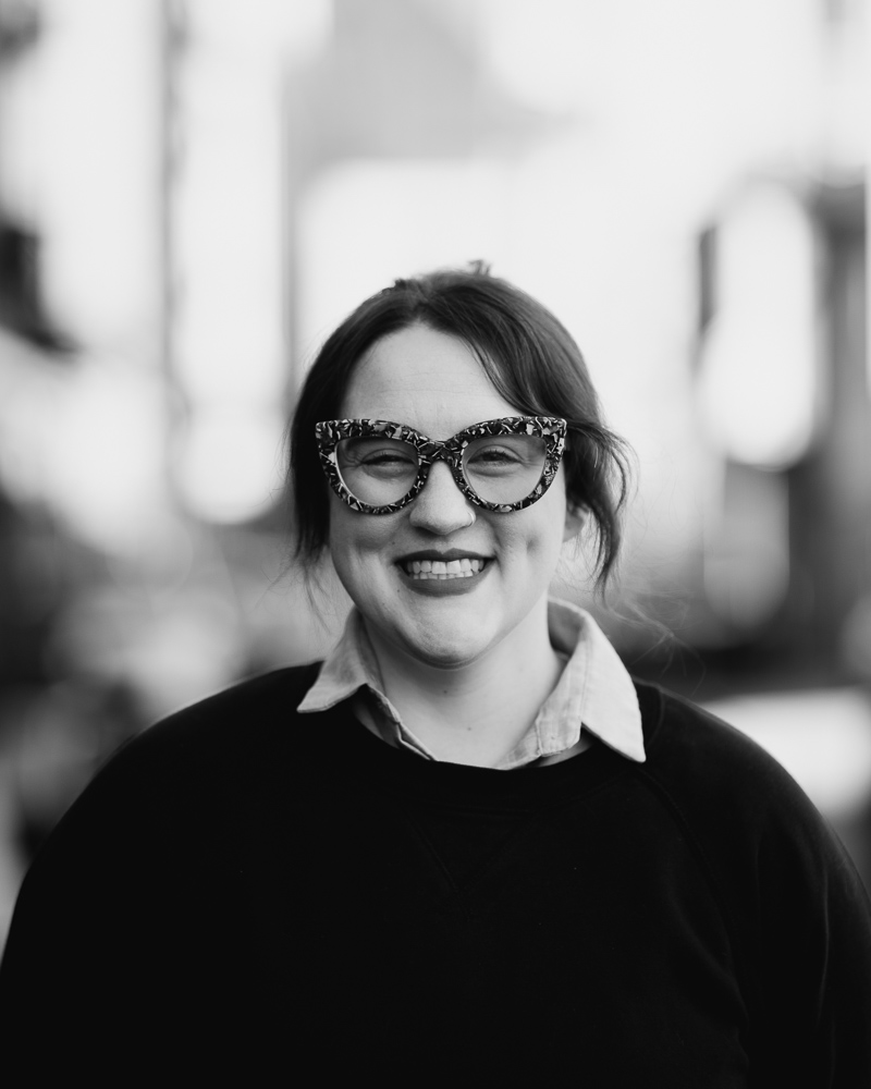 a woman wearing glasses and smiling