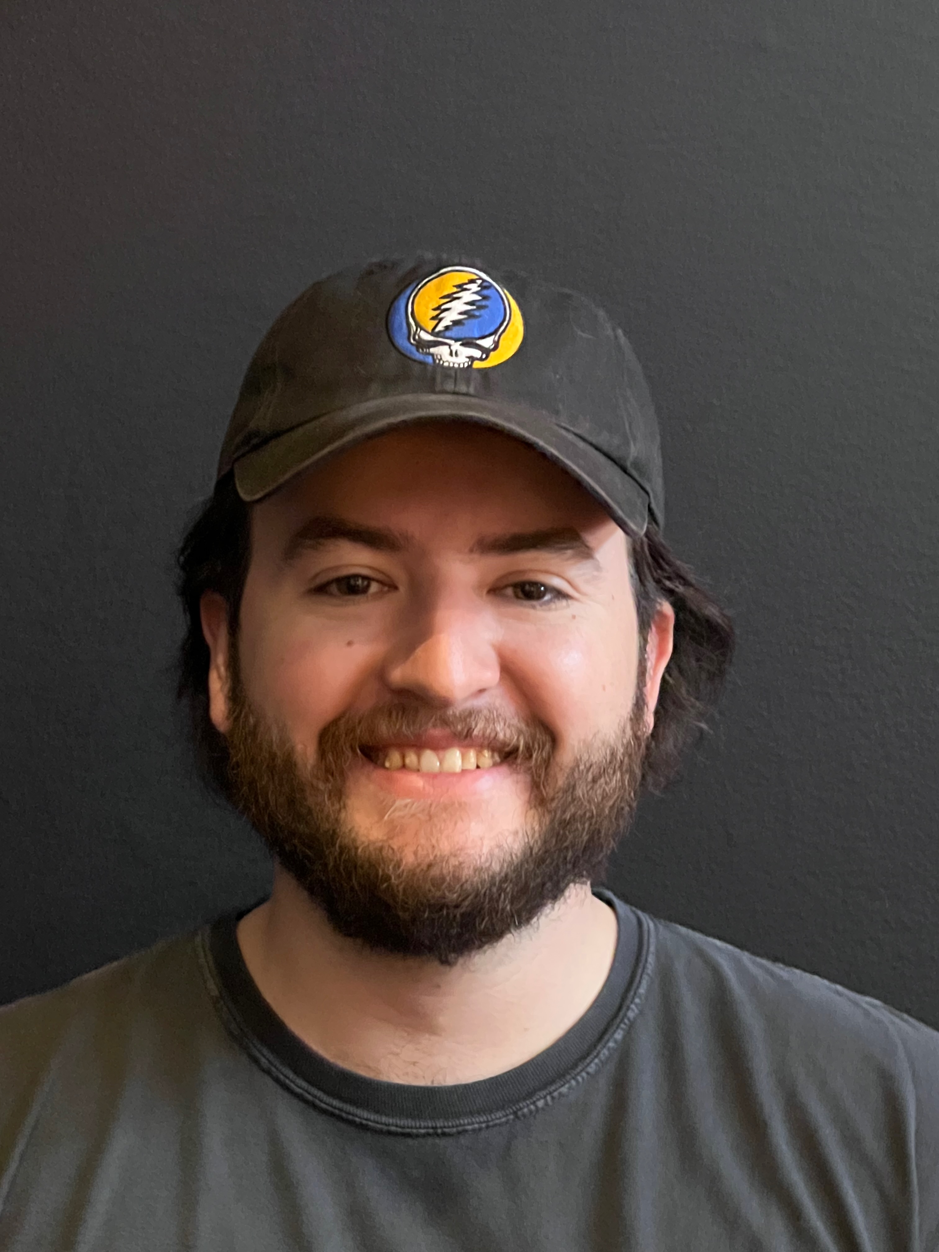 a man wearing a hat and smiling at the camera