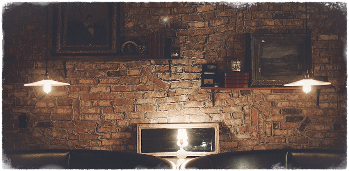 a wall with a window and a lamp in the middle of two couches