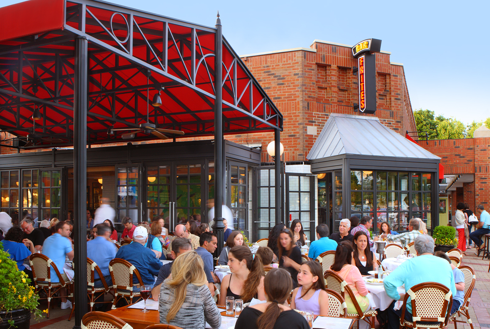 a group of people sitting at a table in front of a building